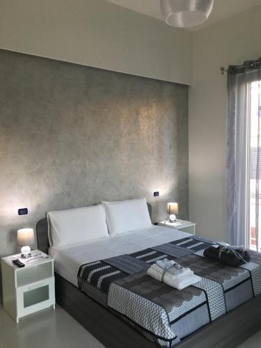 a bedroom with a large bed with two night stands at B&B Vittorio Emanuele in Licata