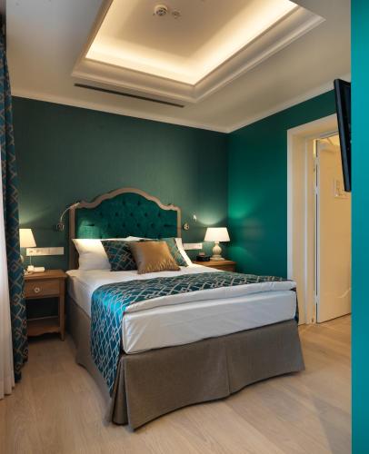 a bedroom with a bed with a green wall at Relais Le Chevalier in Rīga