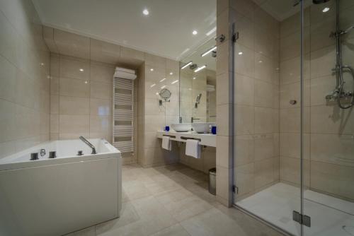 a large bathroom with a tub and a shower at Relais Le Chevalier in Rīga
