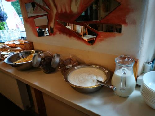 a counter with two bowls of food and a jug of milk at Zrcadlová Koza in Turnov