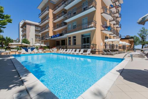 - une piscine en face d'un bâtiment avec des chaises dans l'établissement Hotel Atlas, à Rimini