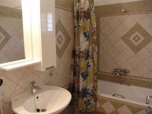 a bathroom with a sink and a shower curtain at Villa Pepy in Mesongi