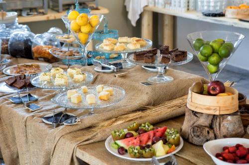 a table topped with plates of food and desserts at Parosland Hotel in Aliki