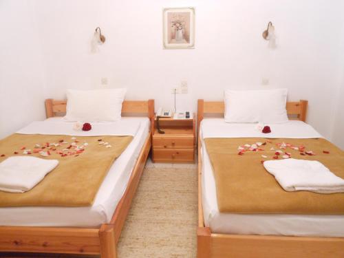 a bedroom with two beds with flowers on them at Studios Maria in Paralion astros
