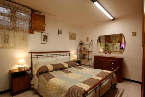 1 dormitorio con cama y espejo en la pared en Casa Mareblù, en SantʼAndrea