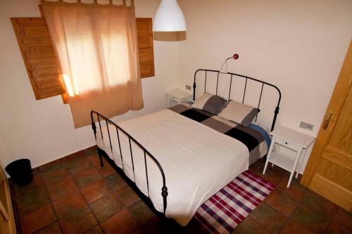 een slaapkamer met een bed, een tafel en een raam bij El mirador del norte in Cortez de Pallas