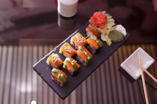 a black plate with sushi on a table at Weekend Boutique Hotel in Chişinău