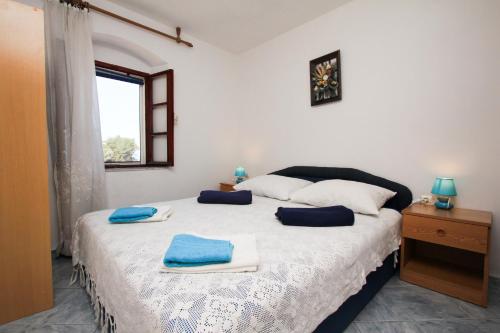 a bedroom with a large bed with blue towels on it at Robinson Braco in Bogomolje