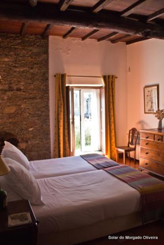 a bedroom with a large bed and a window at Solar do Morgado Oliveira in Macedo de Cavaleiros