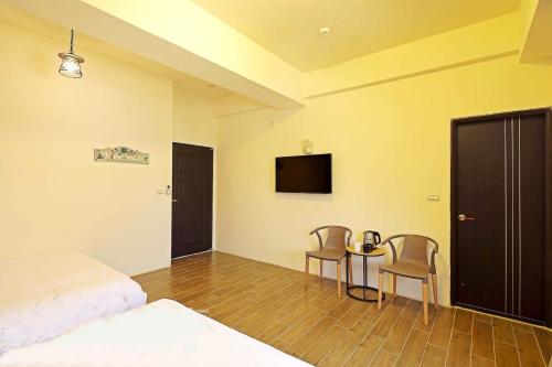 a bedroom with a bed and a table and chairs at Warm Breeze Stay in Hualien City
