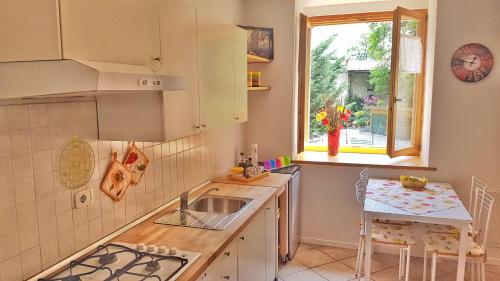 una cucina con lavandino, tavolo e finestra di Appartamento Angi - lago & vacanza attiva a Riva del Garda