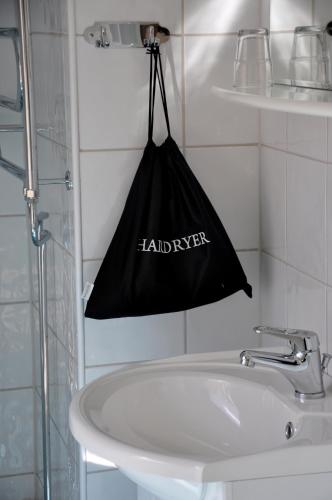 a black bag hanging on a wall above a sink at Hotel Malmkoping, BW Signature Collection in Malmköping