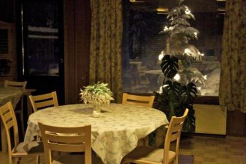 a table with chairs and a vase of flowers on it at Gasthaus Punkaharju in Punkaharju