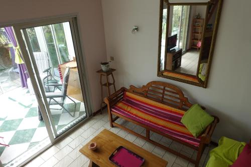 Habitación con banco, mesa y espejo. en Gîte du Fenouil, en Lézignan-Corbières