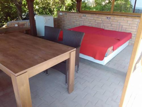 a table and chairs and a bed on a patio at Borospince Vendégház in Pécsely