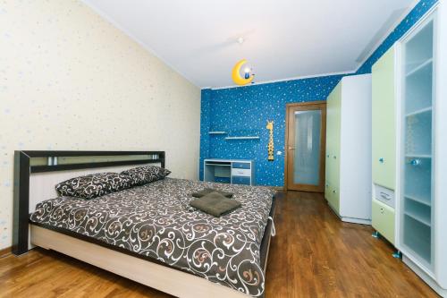 een slaapkamer met een bed en een blauwe muur bij Two-storey apartment near IEC in Kiev