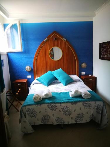 a bedroom with a bed with blue walls and towels at Villa Patrizi in Capri