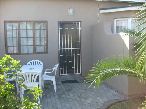 a patio with a table and chairs in front of a house at Huis KlipdriftSelf Catering &B&B in Hentiesbaai