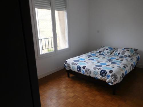 - une chambre avec un lit doté d'une couette et d'une fenêtre dans l'établissement Appartements Caen Centre, à Caen