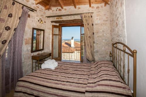 Schlafzimmer mit einem Bett und einem großen Fenster in der Unterkunft Anigraia in Paralio Astros