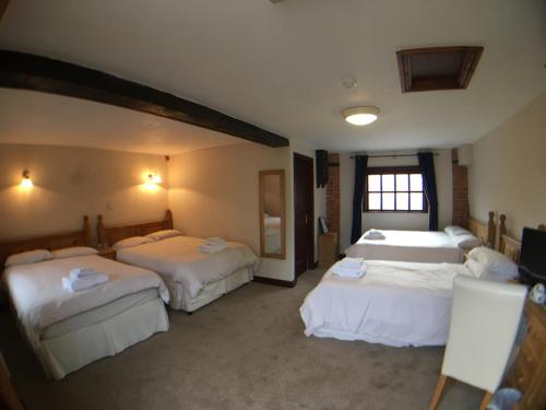 um quarto de hotel com três camas e uma janela em The Lord Nelson em Sutton on Trent