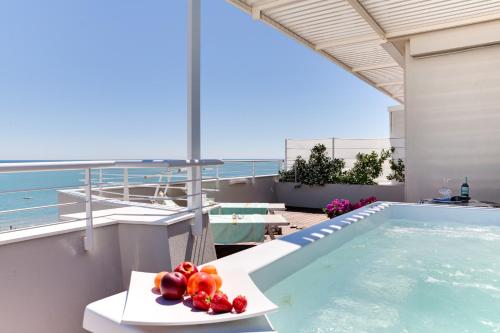 a bowl of fruit on a table next to a swimming pool at Hotel Commodore in Riccione