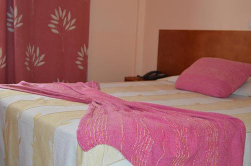 a pink blanket on a bed in a room at Imperio Hotel in Peso da Régua