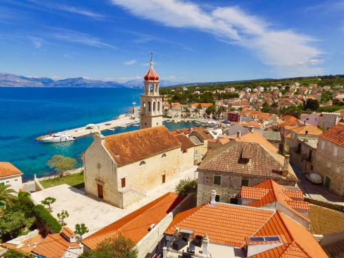 an aerial view of a town with a church and water at Guesthouse Lidija in Sutivan