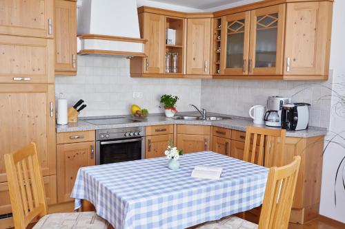 uma cozinha com uma mesa com uma toalha de mesa xadrez em Ferienwohnung Zapf em Oberstdorf