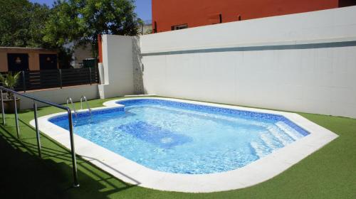 a swimming pool in a yard next to a building at Hotel Spa Pinar del Mar in Platja  d'Aro