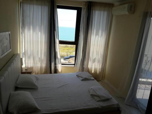 a bedroom with a bed with a view of the ocean at Laguna Beach Hotel in Ravda