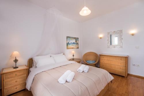 1 dormitorio con 1 cama con 2 toallas en Exotic Palm Villa, en Skotina