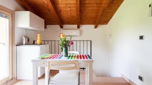 a kitchen with a table with a vase of flowers on it at B&B Nido Sui Laghi in San Donnino della Nizzola