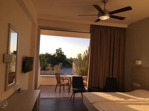 a bedroom with a bed and a view of a patio at Aphrodite Beach Hotel in Polis Chrysochous