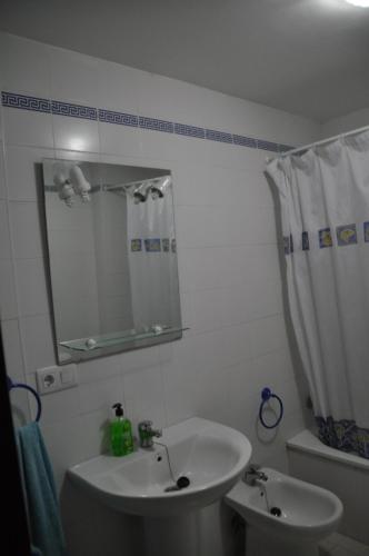 a white bathroom with a sink and a mirror at Mirador de Santiago in Sanlúcar de Barrameda
