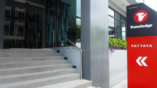 a building with a staircase next to a red sign at Travelodge Pattaya in Pattaya Central