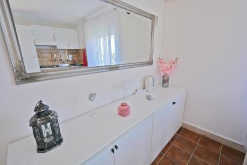 uma casa de banho branca com um espelho e um lavatório em Villa CasaBlanca em Supetar
