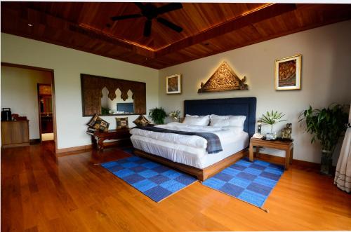 a bedroom with a bed and a ceiling fan at Pa Sak Tong in Chiang Rai