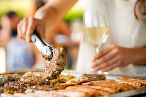 a person is cutting meat with a knife at BIG4 Castlemaine Gardens in Castlemaine