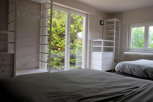 - une chambre avec 2 lits et une grande fenêtre dans l'établissement villa mezennestje, à Oostduinkerke