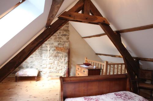 Zimmer im Dachgeschoss mit einem Bett und Holzboden in der Unterkunft Castle Terrace in Faux-la-Montagne