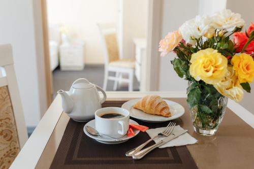 a table with a cup of coffee and a vase of flowers at Asiya in Odesa