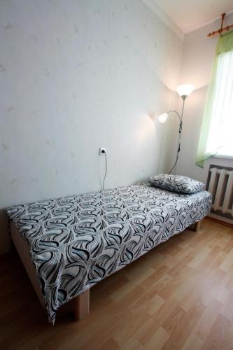 a bedroom with a bed with a black and white comforter at LM Piiri Külaliskorter in Põlva