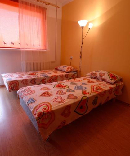 two twin beds in a room with a lamp at LM Piiri Külaliskorter in Põlva