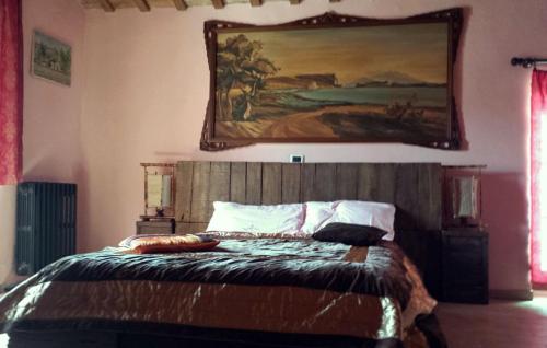 a bedroom with a bed with a painting on the wall at Holidays Cà tassino in Urbino