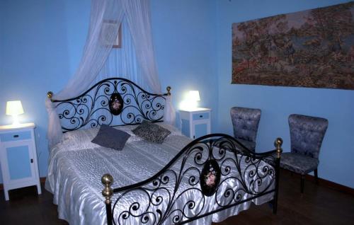 a bedroom with a black and white bed and two chairs at Holidays Cà tassino in Urbino