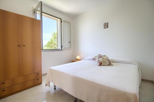 マリーナ・ディ・ペスコルーゼにあるDolce Mimìの白いベッドルーム(大型ベッド1台、窓付)