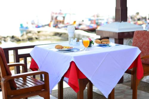 查汶First Bungalow Beach Resort的一张白色桌子,上面放着食物和饮料