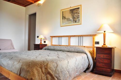 ein Schlafzimmer mit einem großen Bett und zwei Nachttischen in der Unterkunft Villa Dei Romani - Country House in Guidonia