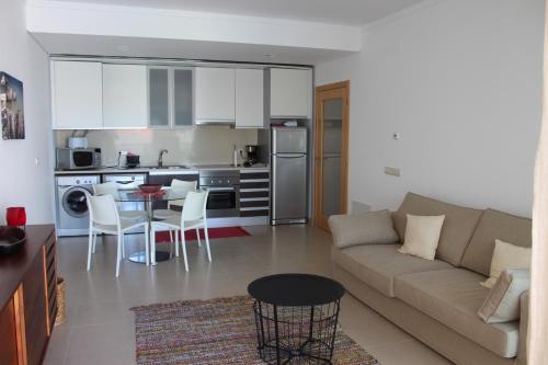 a living room and kitchen with a couch and a table at Modern 1 bedrom apartment in Albufeira